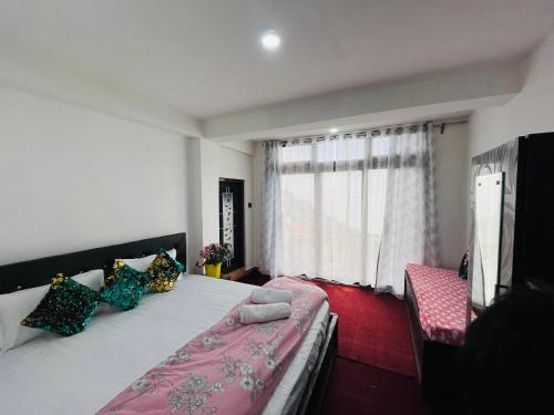 a bedroom with a large bed and a window at shalom inn home stay in Darjeeling