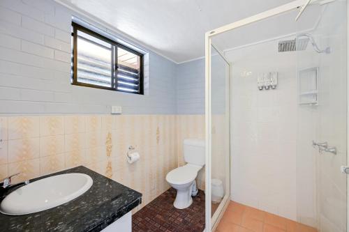 a bathroom with a toilet and a sink and a shower at Raceview Motor Inn in Toowoomba