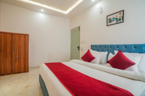 a bedroom with a large bed with red pillows at Hotel The Hidden Door-Near Jaipur Airport in Jaipur