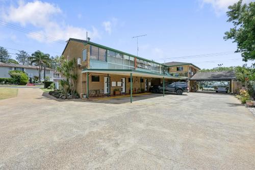 a building with a car parked in a parking lot at Raceview Motor Inn in Toowoomba