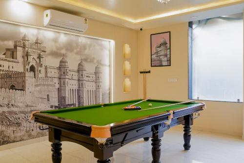 a room with a pool table in front of a painting at Hotel The Hidden Door-Near Jaipur Airport in Jaipur