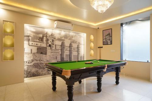a pool table in a room with a painting on the wall at Hotel The Hidden Door-Near Jaipur Airport in Jaipur