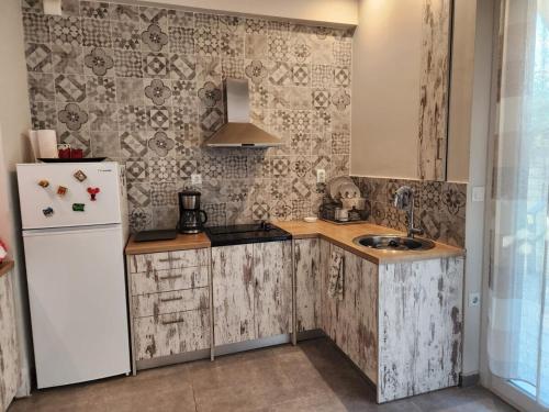 a kitchen with a white refrigerator and a sink at Seaside Escape in Athens