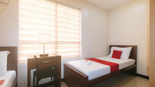 a small bedroom with a bed and a window at RedDoorz at Nucell in Cebu City