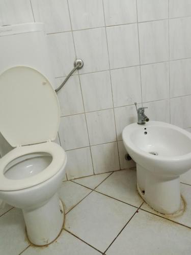 a bathroom with a toilet and a sink at PAVILLION Hill PALACE in Malindi