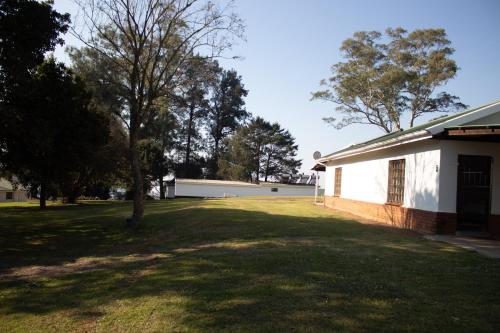a white building with a tree in the yard at Benmore Lodge in Ferrby