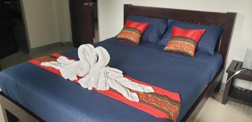 a blue bed with red pillows and a blanket at sengjan garden krabi in Ban Khlong Son