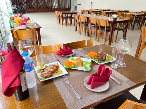 a table with plates of food and a bottle of wine at Juna hotel in Thanh Hóa