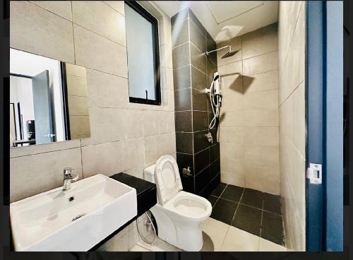 une salle de bain avec des toilettes blanches et un lavabo dans l'établissement Spacious 3BR Retreat Comfort & Style in the City 2-10pax, à Jelutong