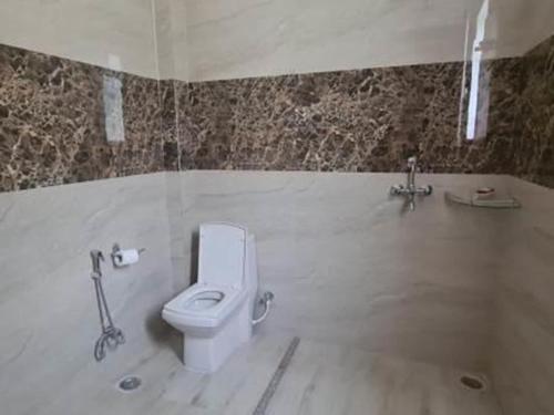 a bathroom with a toilet and a bath tub at Golden Oriole House in Jairāmpura
