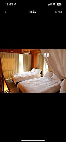 two beds in a room with a window at 南国リゾートBari Okinawa in Itoman