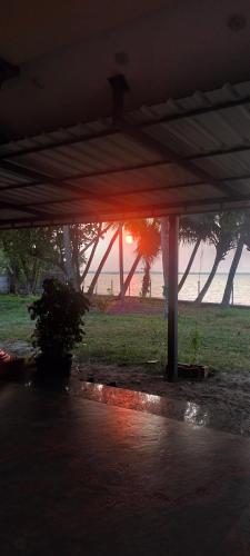 a sunset is seen from under a pavilion at the beach at Blue Lagoon Sambranikodi in Nīndakara