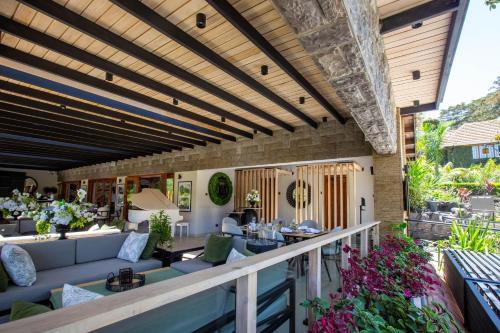 an outdoor patio with couches and tables and flowers at Pax Manor Muthaiga in Nairobi