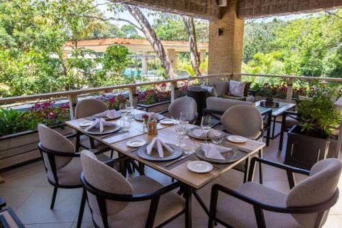 a restaurant with tables and chairs on a balcony at Pax Manor Muthaiga in Nairobi