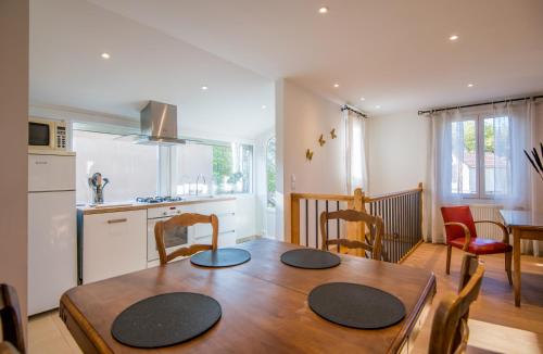 une cuisine et une salle à manger avec une table et des chaises en bois dans l'établissement Villa Margot fibre balcon jardin, à Millau