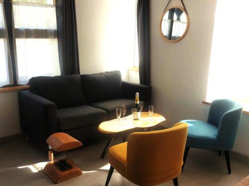 a living room with a couch and a table and chairs at Le Héron in Thury-Harcourt