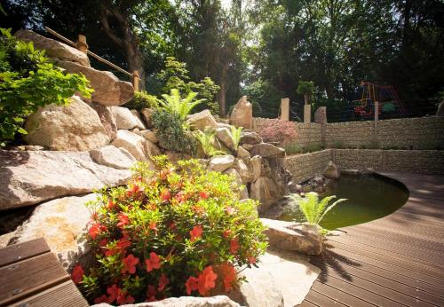 a garden with a pond and some flowers and rocks at Hotel Azenberg in Stuttgart