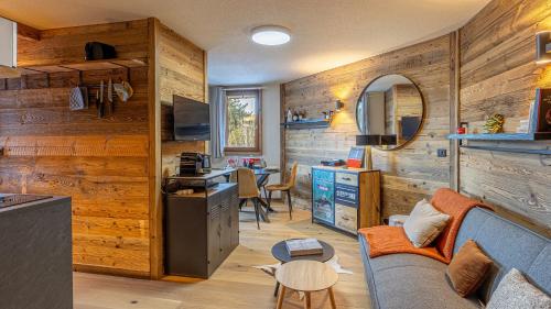Il comprend une cuisine et un salon avec des murs en bois et un canapé. dans l'établissement ViktorSun 7, à La Clusaz