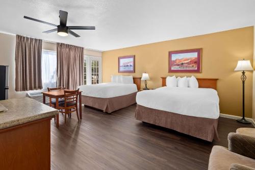 a hotel room with two beds and a table at Clarion Inn in Sierra Vista