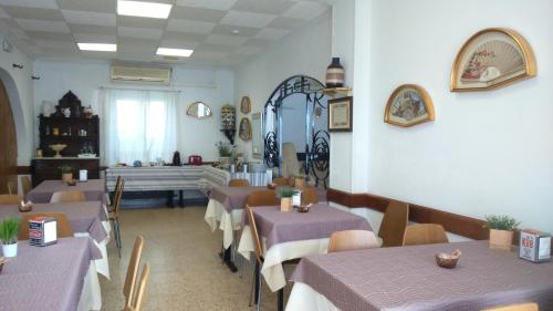 a restaurant with purple tables and chairs and a window at La Masia in Sant Pere Pescador