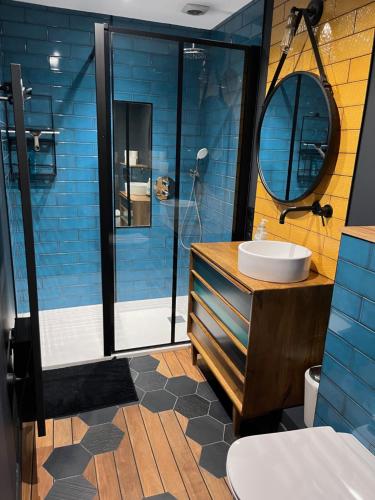 un bagno con lavandino e doccia con piastrelle blu di Grand duplex centre historique a La Rochelle