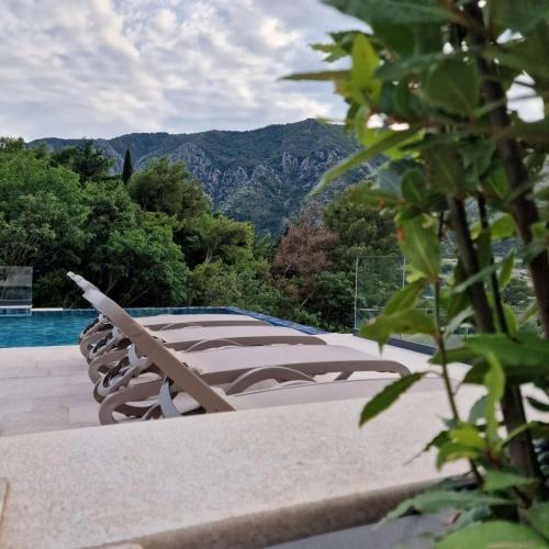 a swimming pool with a view of a mountain at Saint Matthew Place in Dobrota