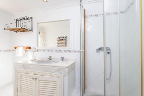 a white bathroom with a sink and a shower at Casa Judith in Muro