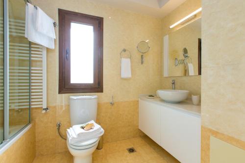 a bathroom with a toilet and a sink at Aria Villas - Private Pool, Playground, Ping Pong & Close to Beach, By ThinkVilla in Pigi