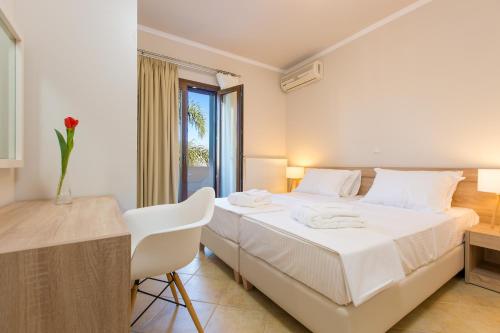 a bedroom with a bed and a desk and a window at Aria Villas - Private Pool, Playground, Ping Pong & Close to Beach, By ThinkVilla in Pigi