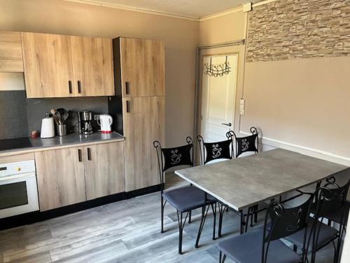 une cuisine avec une table et des chaises dans une cuisine dans l'établissement gite du Breuchin trois, à La Longine