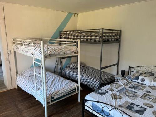 une chambre avec trois lits superposés dans une pièce dans l'établissement gite du Breuchin trois, à La Longine