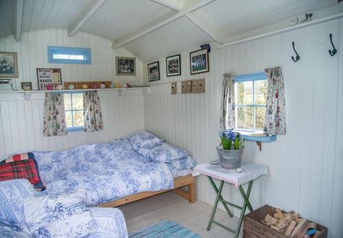a bedroom with a bed and a table and a window at Mollies Hut in Frome