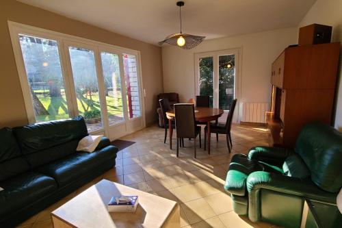 un salon avec un canapé, une table et des chaises dans l'établissement Maison F5 avec jardin à La Teste-de-Buch, à La Teste-de-Buch
