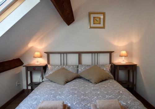 une chambre avec un lit avec deux lampes sur deux tables dans l'établissement Libellule, à Coussac-Bonneval