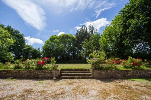 un jardin fleuri et des escaliers dans un parc dans l'établissement Tipoz'immo - 10pax family house near Kermor beach - garden -Wifi included, à Combrit