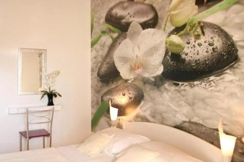 a bedroom with a painting of flowers on the wall at House Roso in Makarska