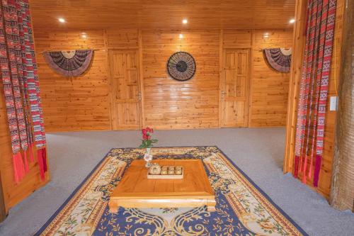 a room with a table in a wooden room at Táo Tày House in Sa Pa