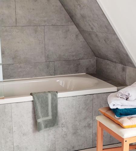 La salle de bains mansardée est pourvue d'une baignoire. dans l'établissement La Résidence des Cordeliers, à Dinan