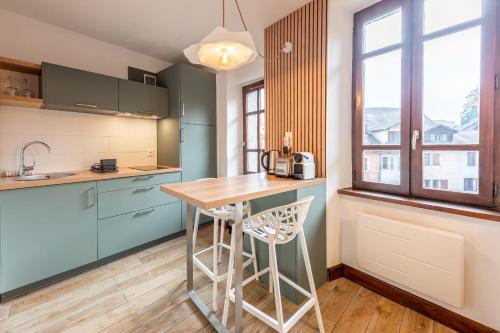 une cuisine avec des placards bleus et un comptoir en bois dans l'établissement Le Bohème, à Annecy