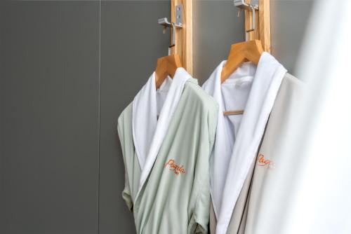 a group of white shirts hanging on a door at Pagoda Hotel Shenzhen Familytrip&BusinessTravel in Shenzhen