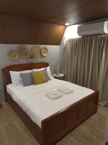 a bedroom with a large bed with two towels on it at Everleigh Resort in Mataasnakahoy