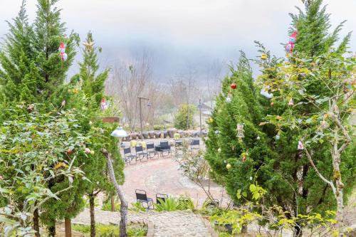 a garden with christmas trees and tables and chairs at Táo Tày House in Sa Pa