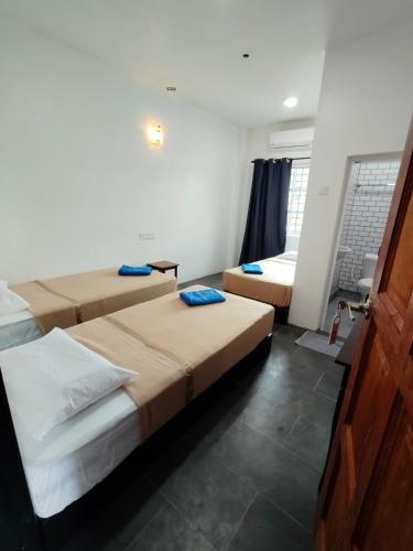 a room with two beds in a room with a window at Perhentian Najmi Hotel in Perhentian Island