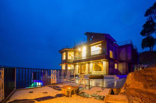 una casa grande de noche con luces encendidas en Alaya Stays Pine Shadow Flamingo Suite with Views & Restaurant, en Jutogh