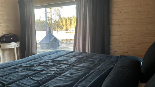 a bedroom with a bed and a large window at Kivisalmi aitta in Viitasaari