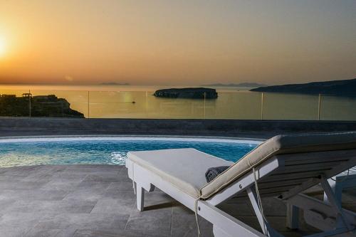 a swimming pool with a bed next to a swimming pool at Our Villa Santorini in Akrotiri