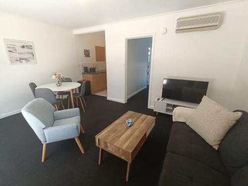 a living room with a couch and a table at Cute, Cosy and Central Apartment 1 in Essendon with Free Parking in Melbourne