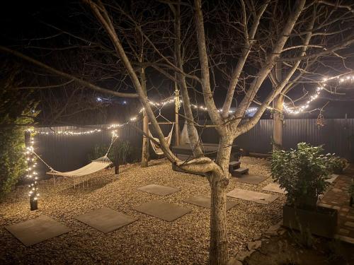 a hammock in a garden at night with lights at Kékmadár Vendégház Alsómégy in Homokmégy