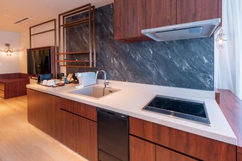 a kitchen with a sink and a stove at Hotel Springs Makuhari Premier in Chiba