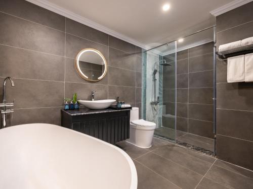 a bathroom with a toilet and a sink and a shower at M'Gloria Cruise by HAG in Ha Long